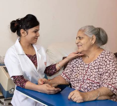 Caregiver smiling with an elderly woman at home